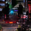 Protesters paint "Stop the cover up" on a private drive outside of where Winston Smith was killed by law enforcement on June 3rd. This was the 2nd time it was painted red in as many days after the red was removed.