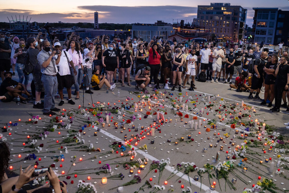 Community gathers around a candle lit vigil where Winston Smith was killed the day earlier by a Federal task force.