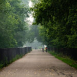 Bikers biking down the Midtown Greenway while wildfire smoke from Canada blankets Minneapolis.