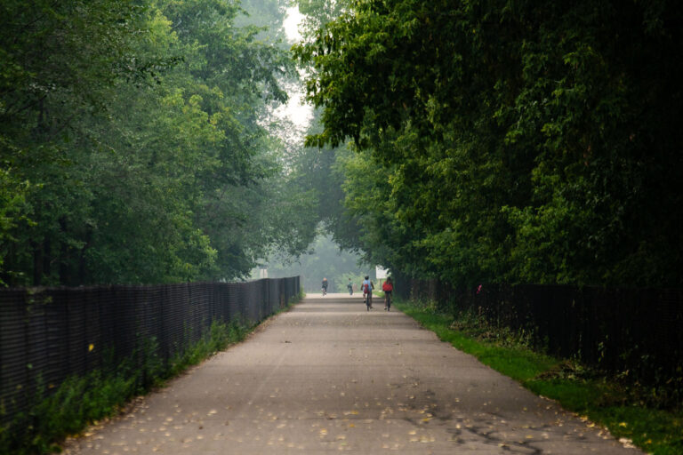 Midtown Greenway bikers with wildfire smoke 3 Bikers biking down the Midtown Greenway while wildfire smoke from Canada blankets Minneapolis.