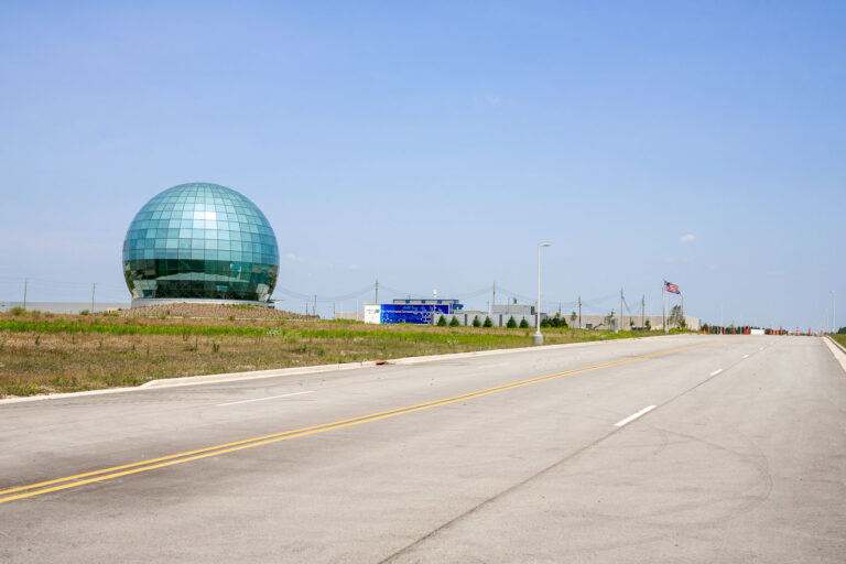 Foxconn Globe on Wisconn Valley Way — Mount Pleasant, WI 2 The distinctive mirrored-glass globe at Foxconn’s Mount Pleasant campus stands along Wisconn Valley Way, a new road constructed specifically for the project. Once envisioned as a hub for LCD panel manufacturing, the complex has evolved into a smaller-scale research and assembly site under Foxconn Industrial Internet. The road, lighting, and landscape reflect the large-scale planning of Wisconsin’s most ambitious economic development project of the late 2010s.