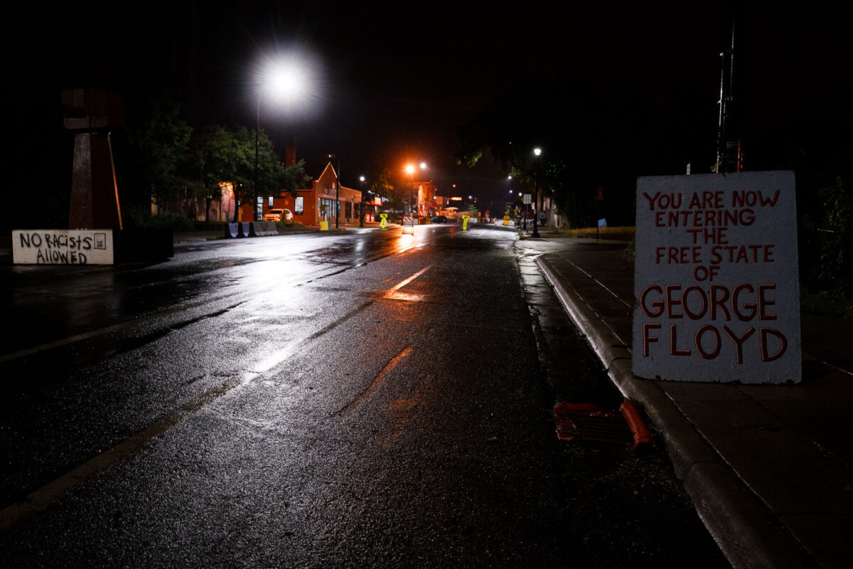 Signs at George Floyd Square on a rainy night in Minneapolis.