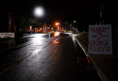 Signs at George Floyd Square on a rainy night in Minneapolis.
