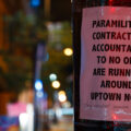 A sign reading "Paramilitary contractors accountable to no one are running around uptown now." with "They assaulted someone last night." added to the bottom. The sign was seen after a private security company cleared and started to patrol the Winston Smith and Deona Marie Memorial sites.