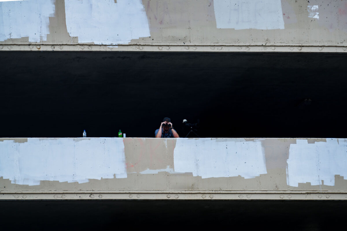 A security guard looks down at those on Lake Street with a pair of binoculars.