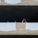 A security guard looks down at those on Lake Street with a pair of binoculars.