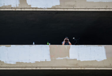 A security guard looks down at those on Lake Street with a pair of binoculars.