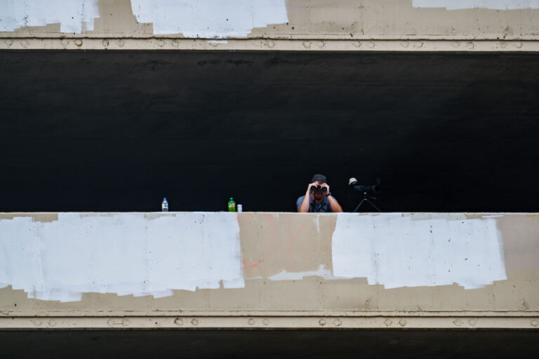 Private Security Surveillance in Uptown 3 A security guard looks down at those on Lake Street with a pair of binoculars.
