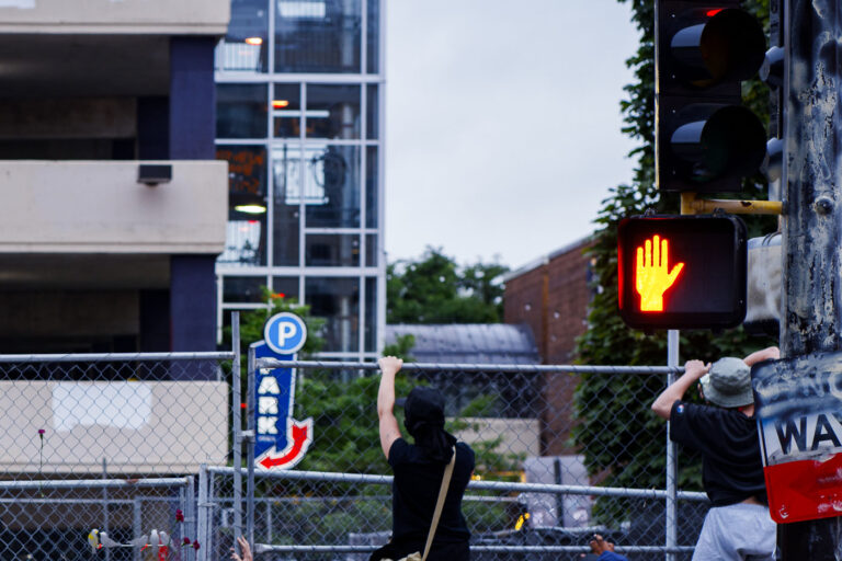 Protesters climb fencing at Winston Smith protest site 2 Protesters climb the fence outside the Winston Smith and Deona Marie memorials. The memorials had been cleared by private security contractors earlier in the morning.