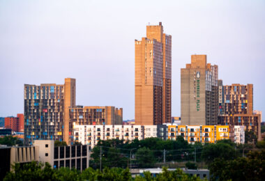 Riverside Plaza, a defining feature of the Cedar-Riverside neighborhood in Minneapolis, reflects the city’s 1970s experiment with large-scale urban housing. Designed by architect Ralph Rapson and completed in 1973, the complex was built as part of the federal urban renewal program and stands out for its Brutalist concrete design and colorful panels. Often referred to locally as “Little Mogadishu” due to its large Somali community, the towers remain a prominent symbol of both the city’s architectural ambition and its layered immigrant history.