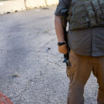 Armed security from Conflict Resolution Group inside a fence at Seven Points Mall. The area was the site of protests following the killing of Winston Smith by federal law enforcement officers the month earlier.