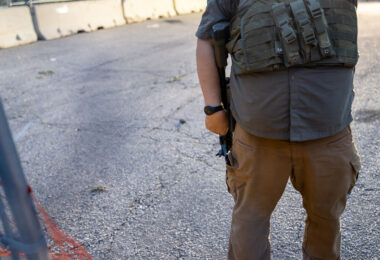 Armed security from Conflict Resolution Group inside a fence at Seven Points Mall. The area was the site of protests following the killing of Winston Smith by federal law enforcement officers the month earlier.