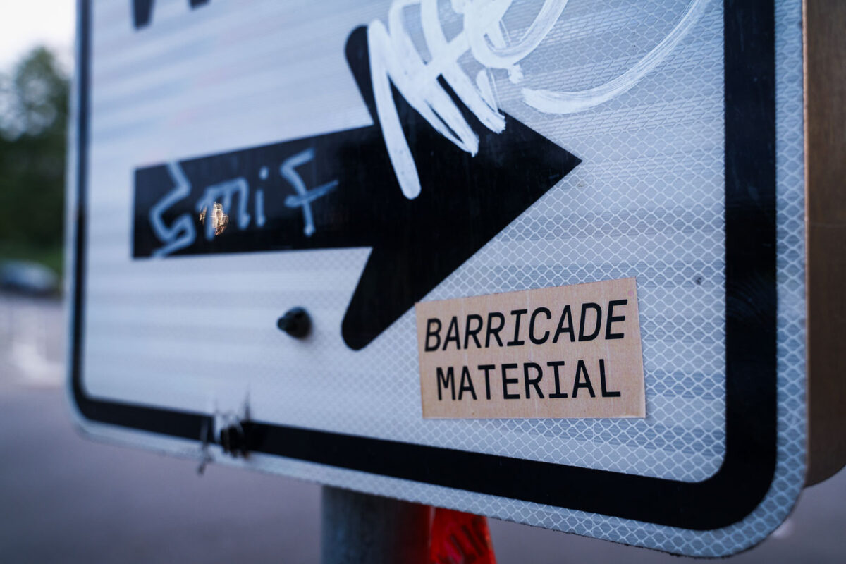 A sticker reading "BARRICADE MATERIAL" referring to the heavy use of just about anything available to create barricades in the streets during unrest.