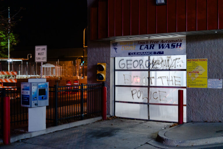 Evict The Police on building across from police station 1 The Stop N Shop car wash across from the Minneapolis Police fifth precinct.