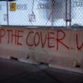 "Stop The Cover Up" painted on a concrete barrier outside the parking ramp where Winston Smith was killed by law enforcement.