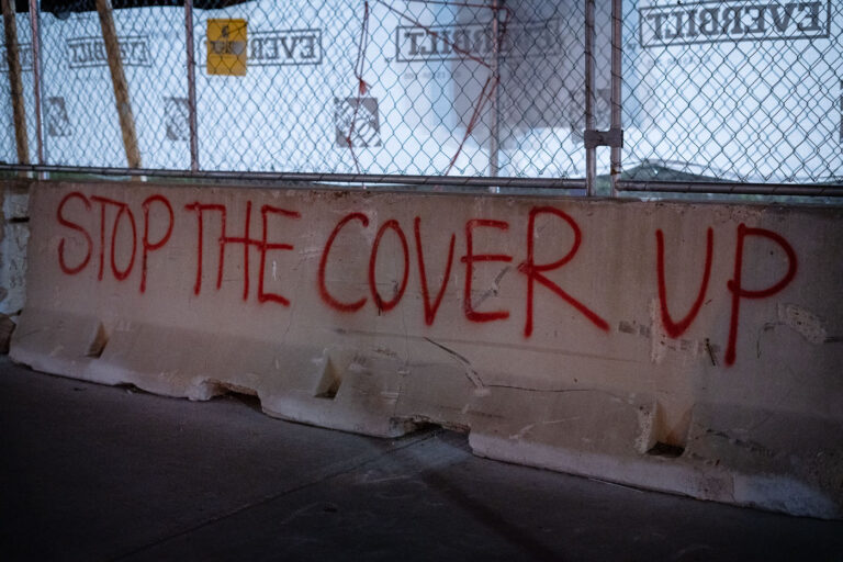 Stop The Cover Up graffiti 1 "Stop The Cover Up" painted on a concrete barrier outside the parking ramp where Winston Smith was killed by law enforcement.