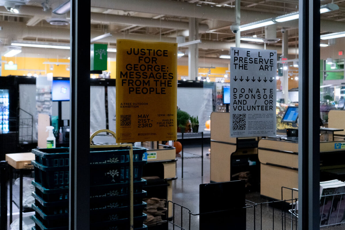 Signs hang in the window of the Seward Community Co-op.