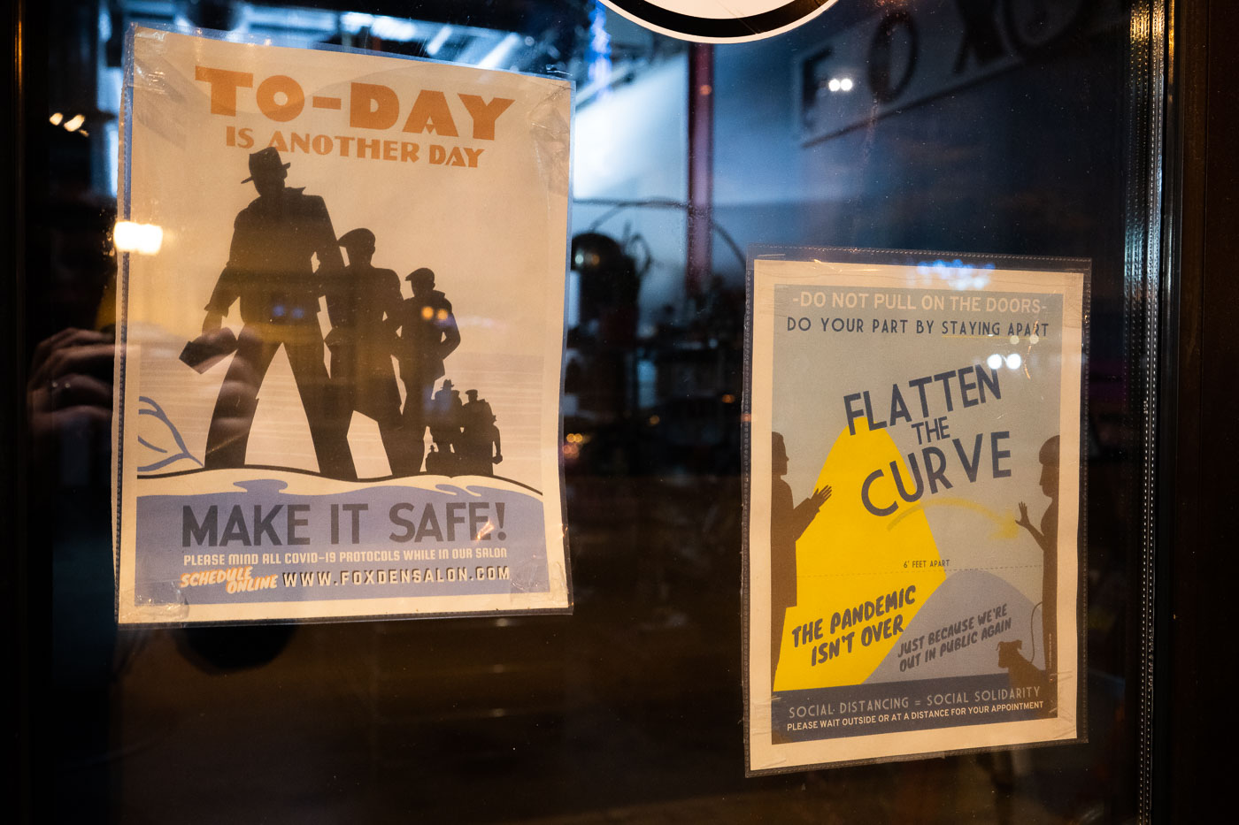 COVID-19 safety signs at Fox Den Salon in Uptown Minneapolis encourage social distancing and online appointments to mitigate virus spread.