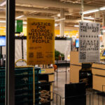 Signs hang in the window of the Seward Community Co-op.