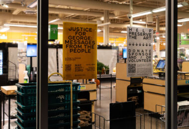 Signs hang in the window of the Seward Community Co-op.