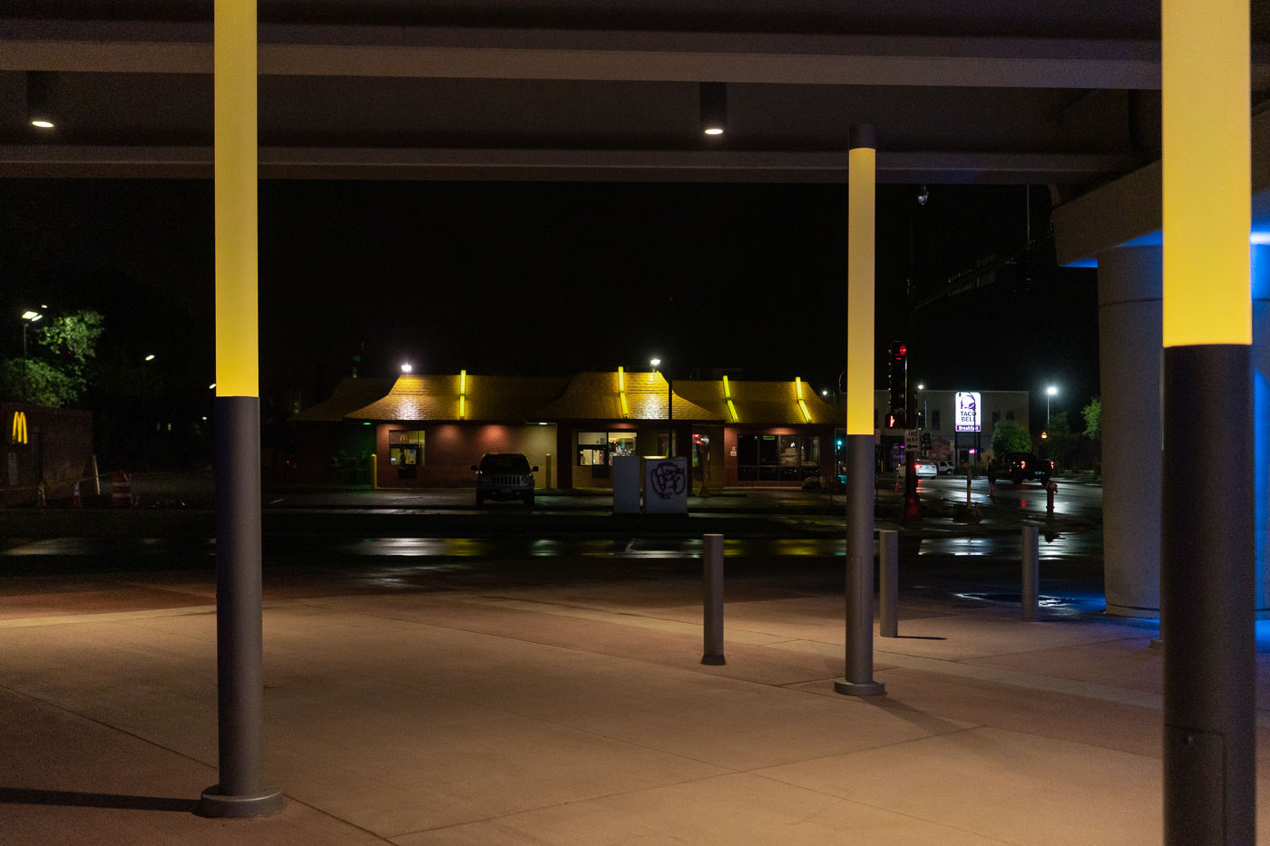 The I-35W Lake Street Station in Minneapolis is illuminated at night, with nearby McDonald's and Taco Bell establishments visible.
