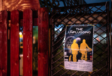 A flyer for The Unplugging by New Native Theatre at the site of the former Gandhi Mahal Site that burned down during unrest.