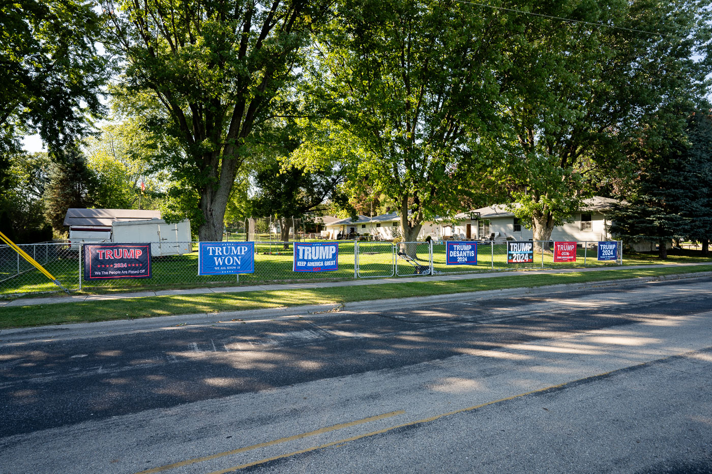 Campaign signs supporting Donald Trump for 2024 and "Trump Won" are displayed on a fence in Freedom, Wisconsin, September 2021.