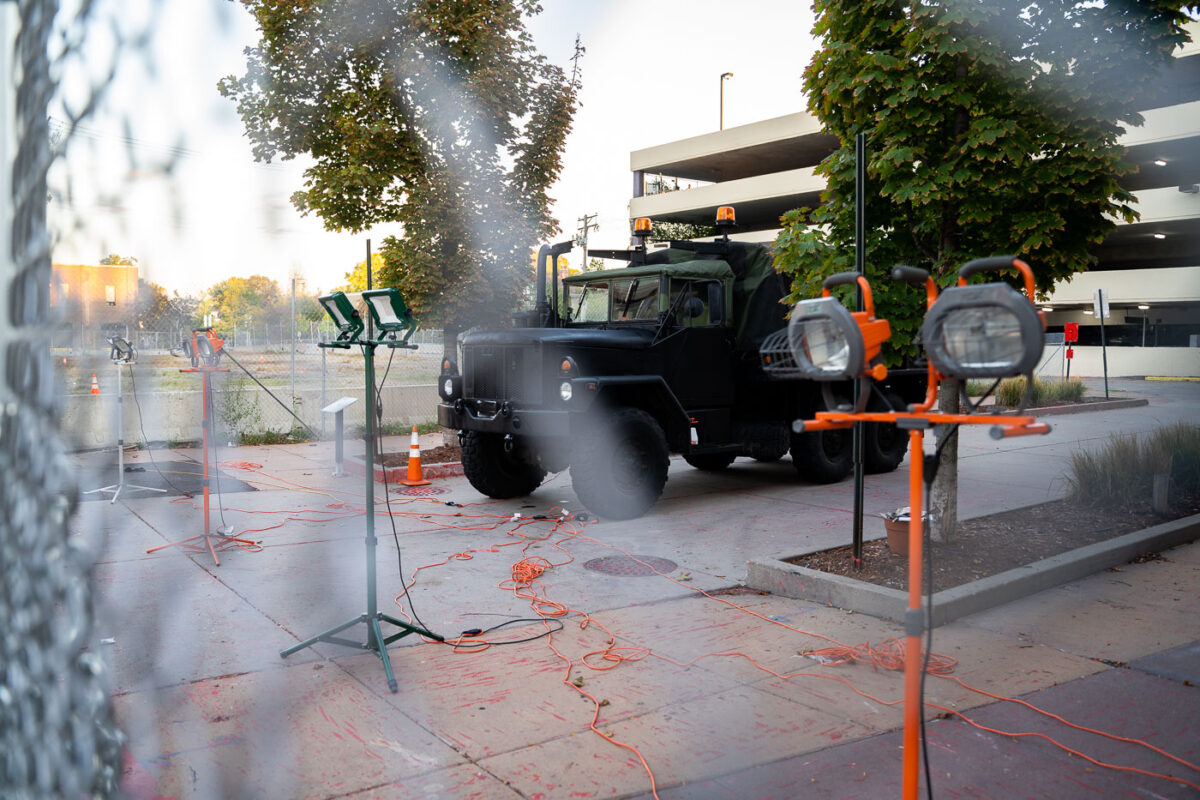 A military type vehicle parked behind layer of fencing and lights outside of Seven Points mall.