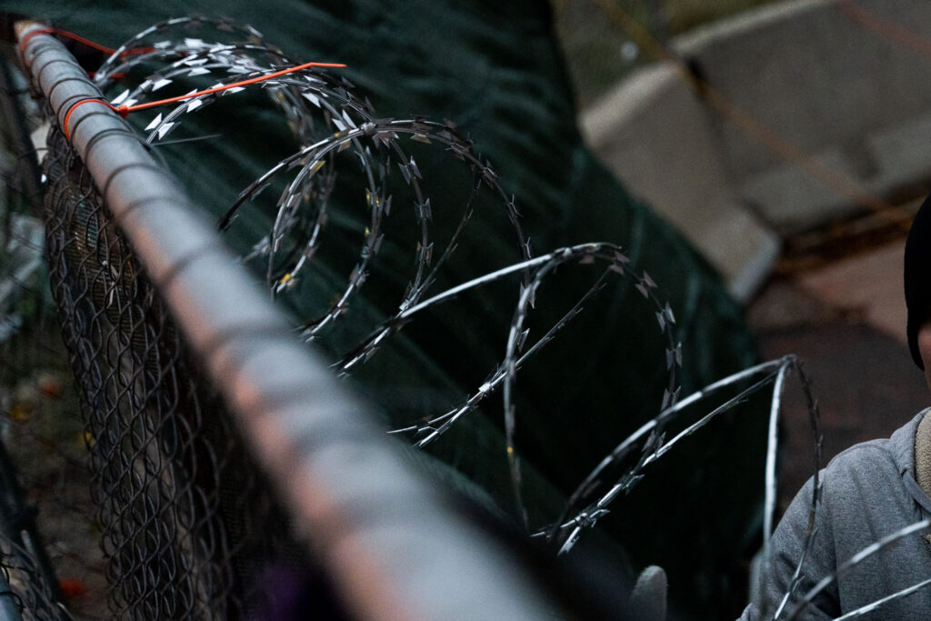 Security installs razor wire on top of fencing around the parking garage at Lake & Girard where Winston Smith was killed on June 3rd, 2021. This comes the day before the County Attorney announces they will not be charging the unidentified officers who shot and killed Winston Smith as part of a federal task force.