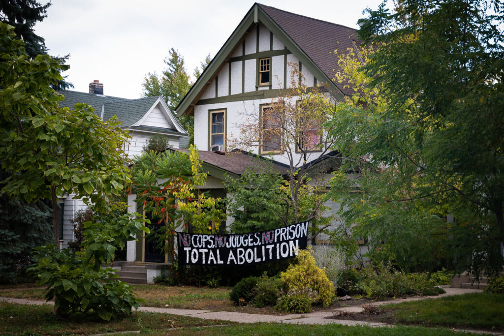 A home with a "No Cops, No Judges, No Prison Total Abolition" banner on their home during Open Streets Lyndale 2021.