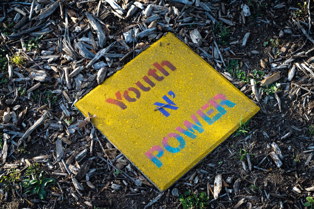 "Youth N' Power" written on a stone near the Say Their Names Memorial.