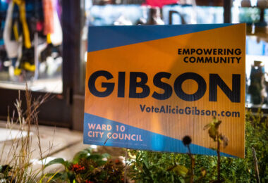 A campaign sign for Alicia Gibson stands outside a neighborhood storefront in Minneapolis’ Ward 10, a district centered on Uptown, Whittier, and parts of South Minneapolis. Ward 10 has long been one of the city’s most politically active areas, shaped by rental-heavy housing stock, transit-focused neighborhoods, and dense commercial corridors around Hennepin, Lyndale, and Lake Street. Campaign signs became common across the ward during the municipal election cycle as candidates addressed issues central to this part of the city: small-business recovery, housing policy, cycling and pedestrian infrastructure, and the future of Uptown’s commercial identity.

Historically, Ward 10 has been a bellwether for broader citywide political shifts. Its mix of long-term residents, young renters, and small-business owners has kept competition high and civic turnout strong. In recent years, community debates over zoning updates, transportation improvements, and neighborhood redevelopment have made Ward 10 races especially watched, with campaigns frequently engaging directly with street-level concerns and neighborhood-driven organizing.