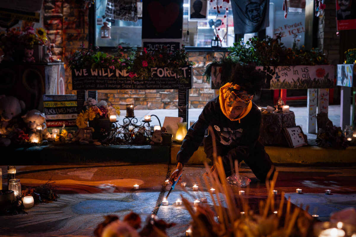Caretaker lights candles at George Floyd Memorial