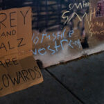 A sign reading "Frey and Walz are cowards" in Uptown Minneapolis - referring to Mayor Jacob Frey and Governor Tim Walz.