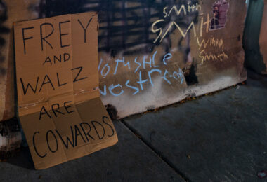 A sign reading "Frey and Walz are cowards" in Uptown Minneapolis - referring to Mayor Jacob Frey and Governor Tim Walz.