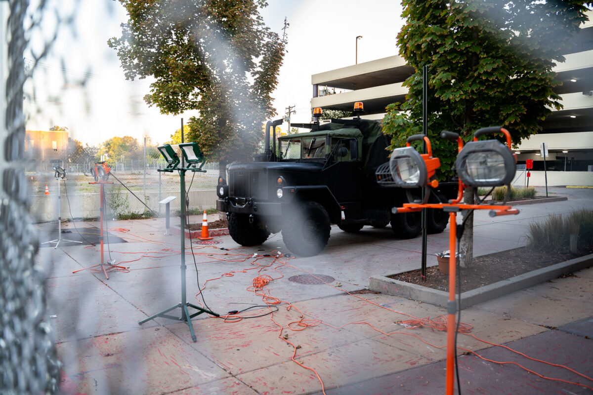 A military type vehicle parked behind layer of fencing and lights outside of Seven Points mall.