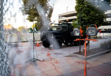 A military type vehicle parked behind layer of fencing and lights outside of Seven Points mall.