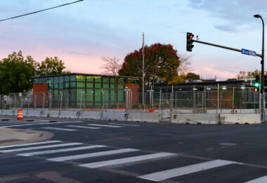 The Minneapolis Police Fifth Precinct with security fencing and concrete barricades surrounding it.