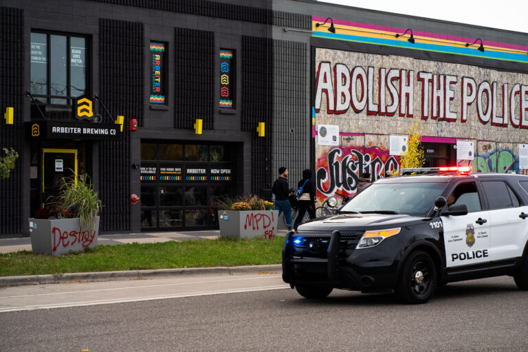Minneapolis Police Squad Car and Abolish The Police 1 A Minneapolis Police squad drives down Minnehaha Ave as Open Streets finishes up.