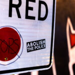 An Abolish The Police sticker on a No Turn on Red sign in Uptown Minneapolis.