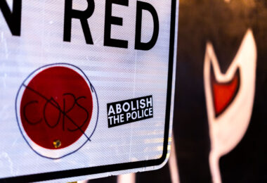 An Abolish The Police sticker on a No Turn on Red sign in Uptown Minneapolis.
