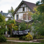 A home with a "No Cops, No Judges, No Prison Total Abolition" banner on their home during Open Streets Lyndale 2021.