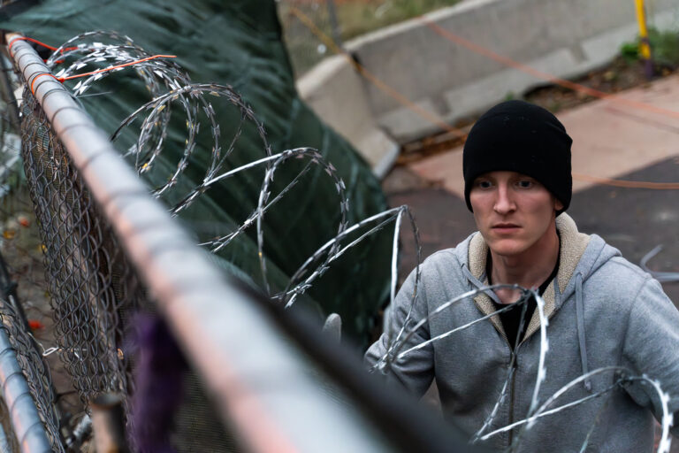 Private security installing razor wire 1 Security installs razor wire on top of fencing around the parking garage at Lake & Girard where Winston Smith was killed on June 3rd, 2021. This comes the day before the County Attorney announces they will not be charging the unidentified officers who shot and killed Winston Smith as part of a federal task force.