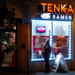Woman looking at the menu in the window at Tenka Ramen on Lake Street in Uptown Minneapolis.