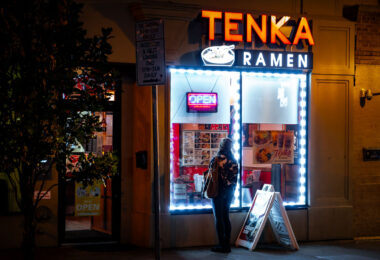 Woman looking at the menu in the window at Tenka Ramen on Lake Street in Uptown Minneapolis.