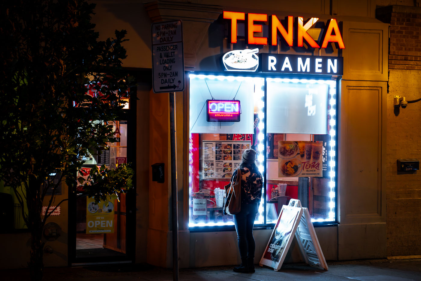 Woman looks in the window of Tenka Ramen in Minneapolis