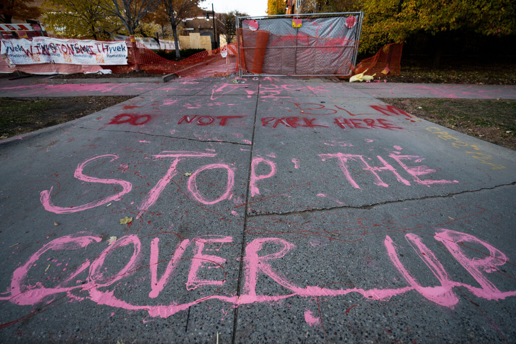 Protesters paint "Stop The Cover Up" outside the parking garage where Winston Smith was killed by law enforcement 5 months earlier.