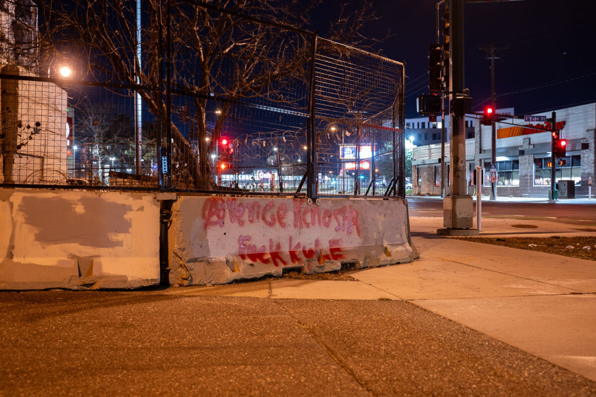 "Avenge Kenosha" and “Fuck Kyle” written on the barriers surrounding the third precinct.