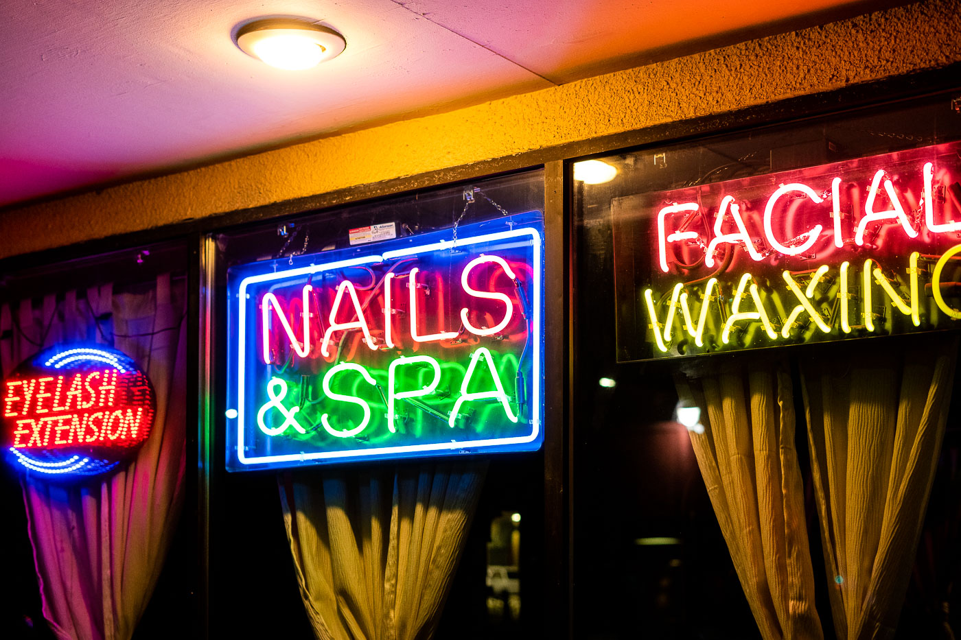 Neon signs for Nails & Spa, Facial Waxing, and Eyelash Extension glow brightly in Minneapolis.