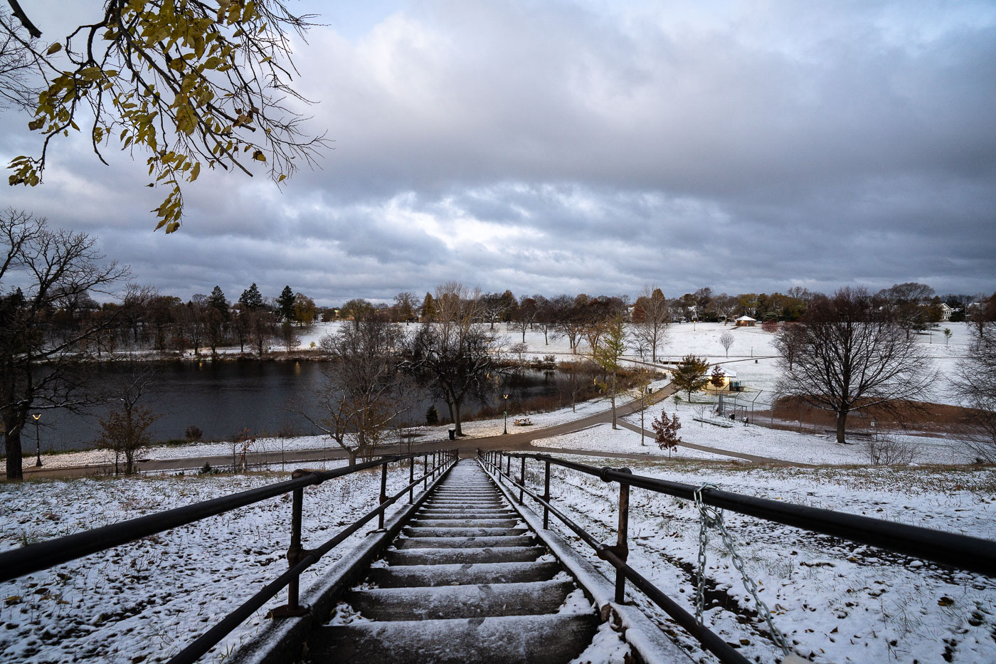 Powderhorn Park in Minneapolis on a snowy morning after the first snowfall of the season. The park, established in 1889, is a vital green space with a lake and walking paths.